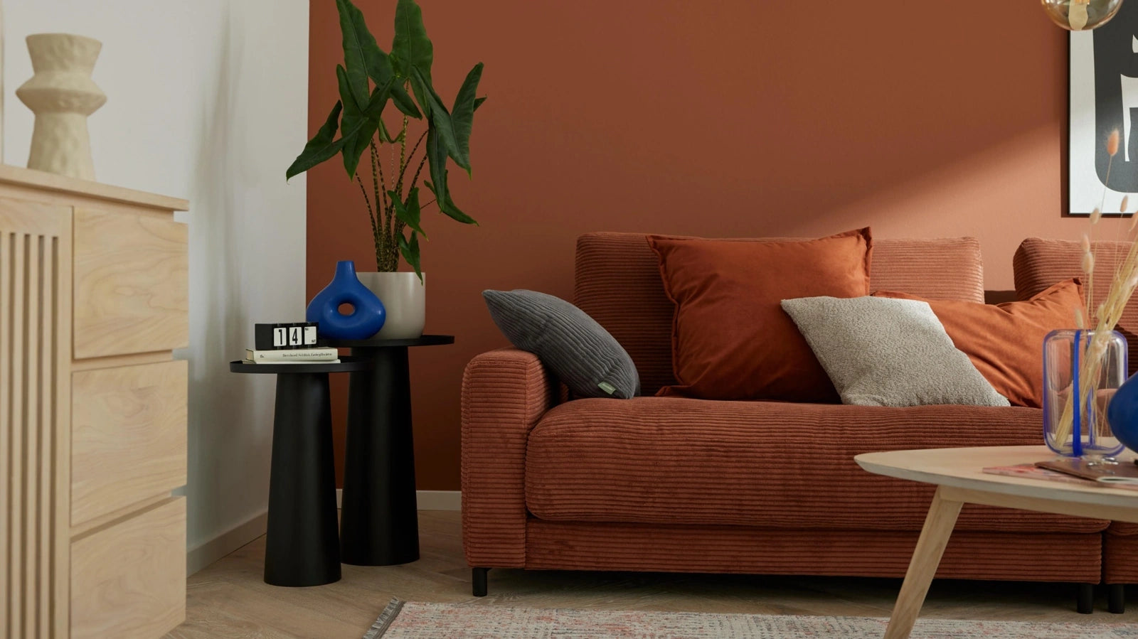 Cord-Sofa in Cognac im Wohnzimmer mit Dekokissen, modernes Polstermöbel
