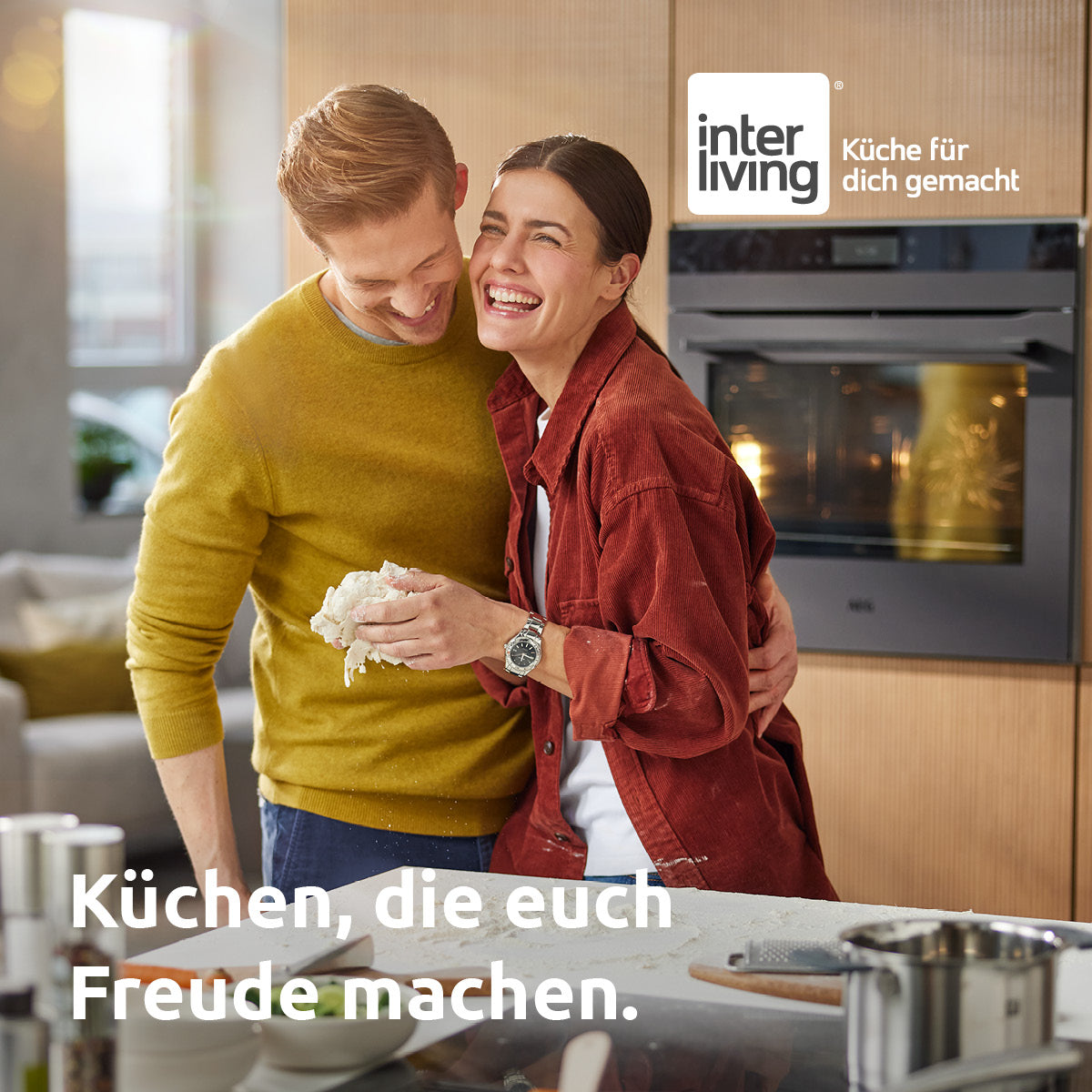 Paar lacht gemeinsam beim Backen in der Küche – persönlicher Service und Betreuung bei Interliving FREY