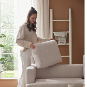 Frau setzt ein Rückenkissen auf das Interliving Serie 4450 Ecksofa, Detail zur Polsterung
