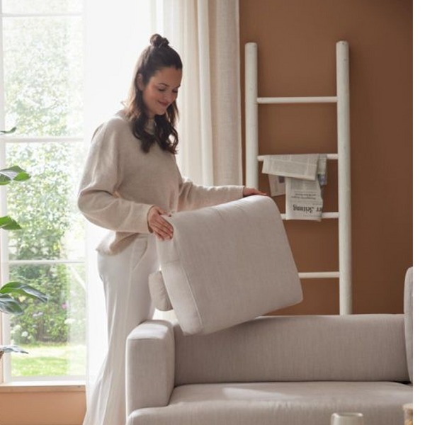 Frau setzt ein Rückenkissen auf das Interliving Serie 4450 Ecksofa, Detail zur Polsterung