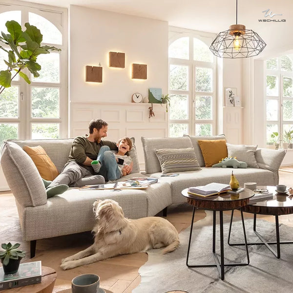 Großes Familiensofa von W.Schillig mit Vater, Kind und Hund in heller Wohnatmosphäre